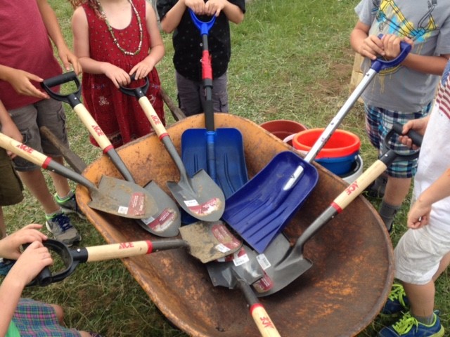 kids with shovels and a wheelbarrow