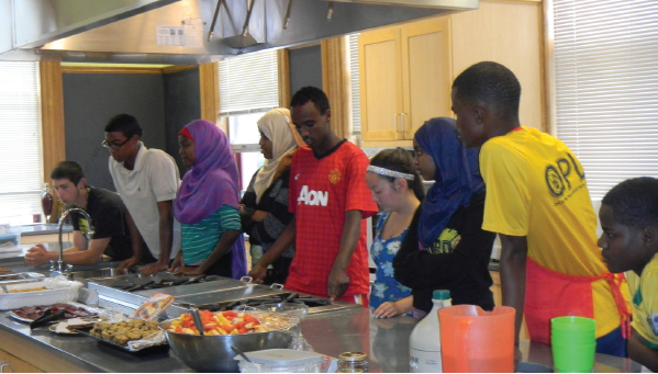 Participants learning and cooking in a kitchen.