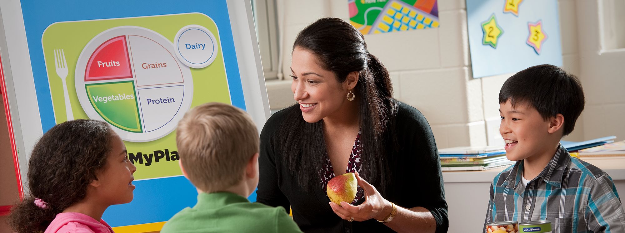 an adult talks to children about MyPlate