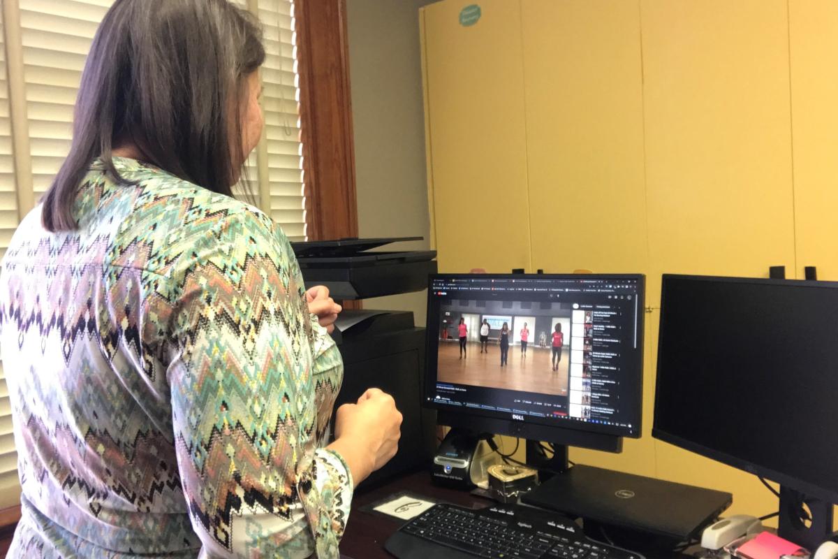 participant follows along with a virtual workout on home computer