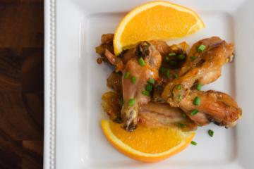 Chicken wings on a plate with orange slices