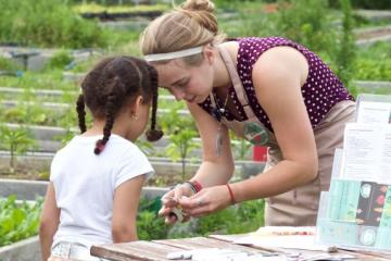 A nutrition educator shares nutrition information at a garden setting.