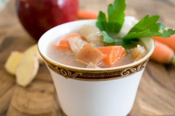 apple carrot soup in a teacup with parsley garnish