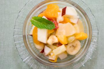 fruit salad in a bowl with a mint garnish