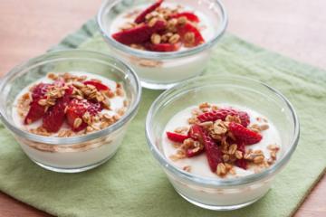 3 bowls of parfait and strawberries on a green napkin