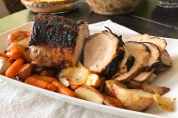 Pork loin with roasted vegetables on a serving platter