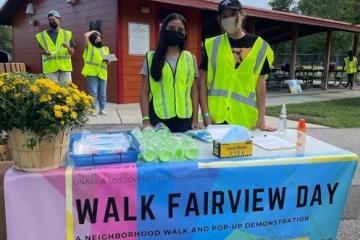 participants from the Walk Fairview Day stand behind a table with a sign