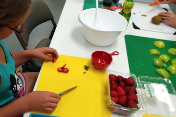 girl cutting up strawberries