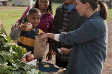 family purchasing prodice with EBT card at a farmers market