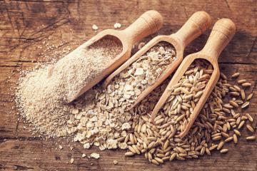 three different whole grains on a wooden background