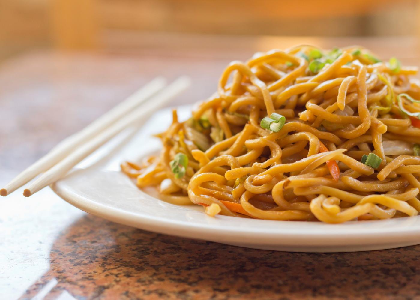 Fried noodles on a plate with chopsticks