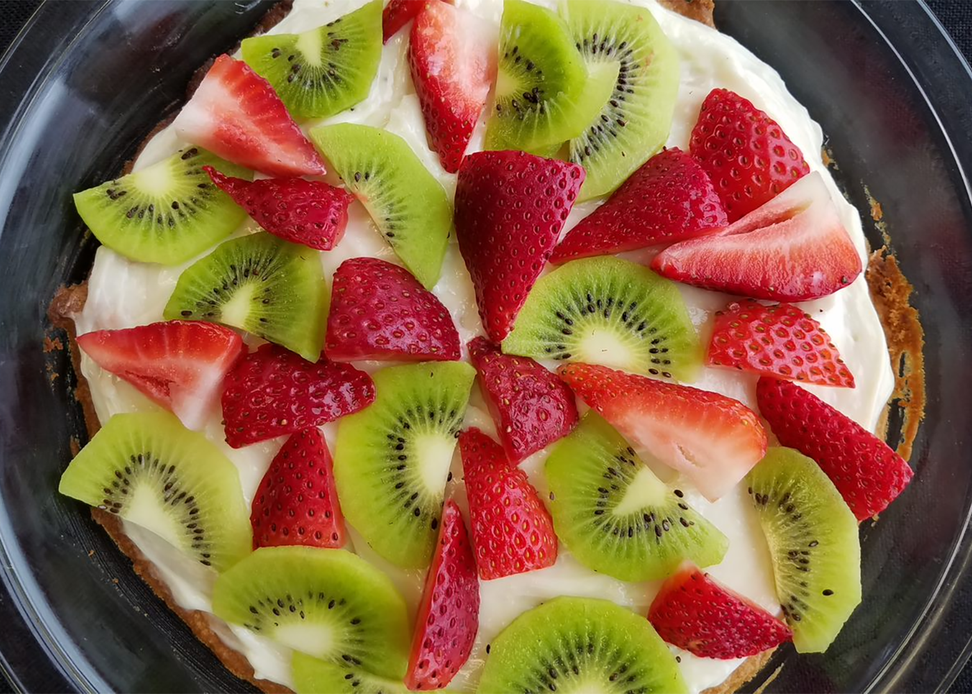 Fruit Pizza with sliced kiwifruit and strawberries.