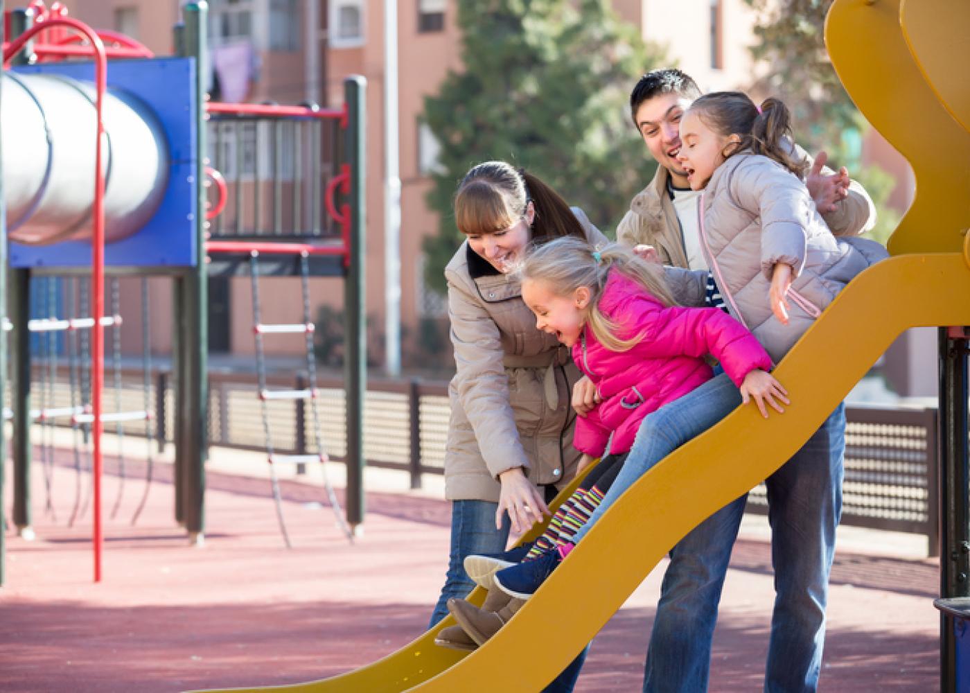 family playing with kids at an urban playground