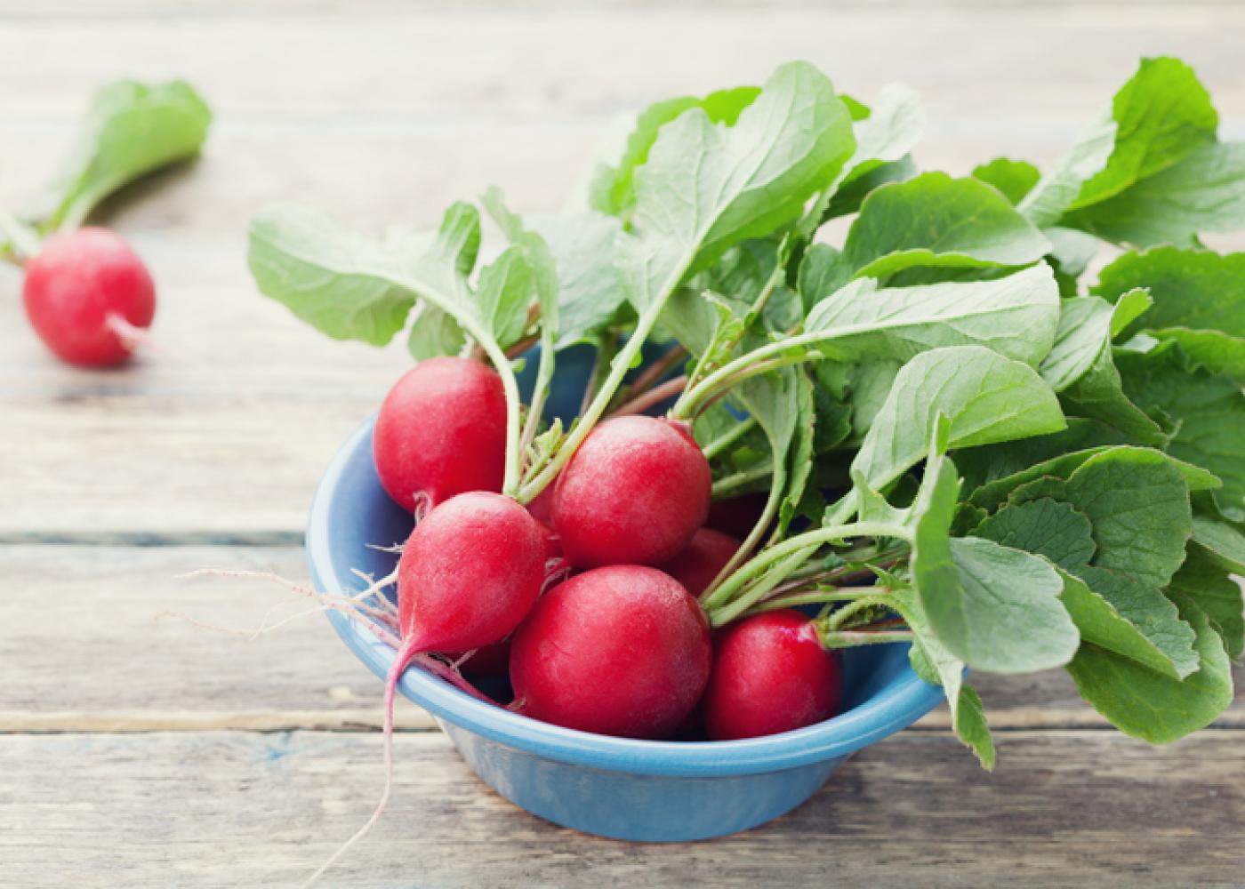 radishes with their green tops in a bowl