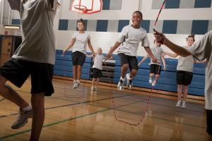 A group of children jump rope in a gymnasium 