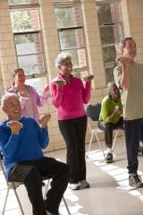 A group of older adults lifting handweights in an exercise class